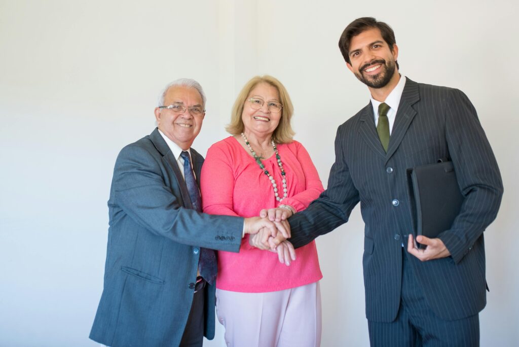 Smiling senior couple meeting with a real estate agent indoors, signifying a successful deal.